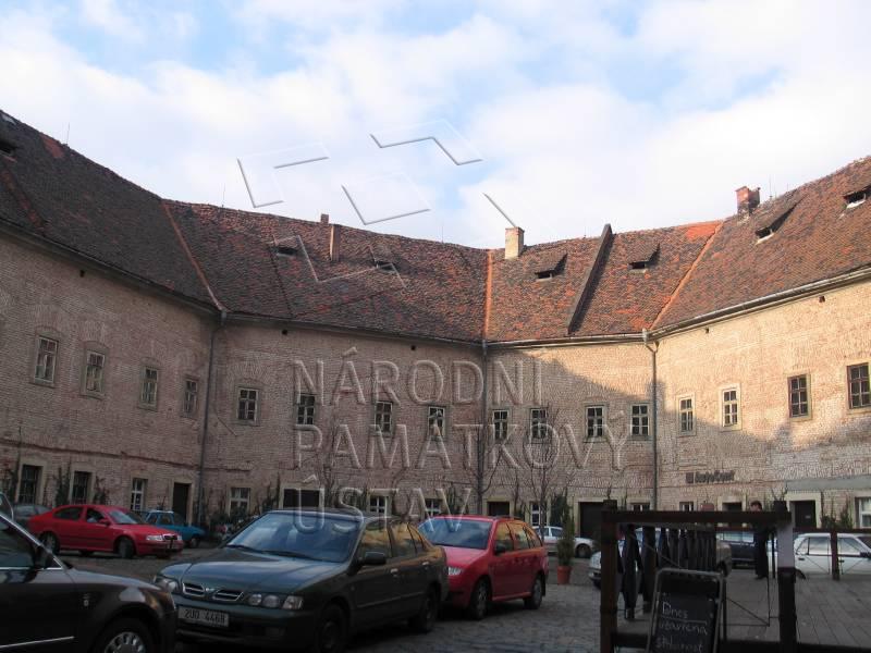 Vnitřní nádvoří Podkovy s parkujícími auty, pohled na podkovovitou budovu